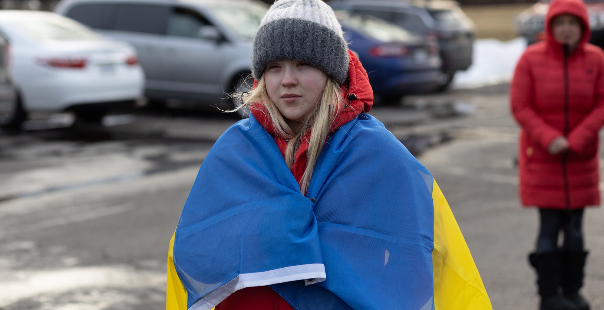Ein junges Mädchen trägt eine Ukraine-Flagge